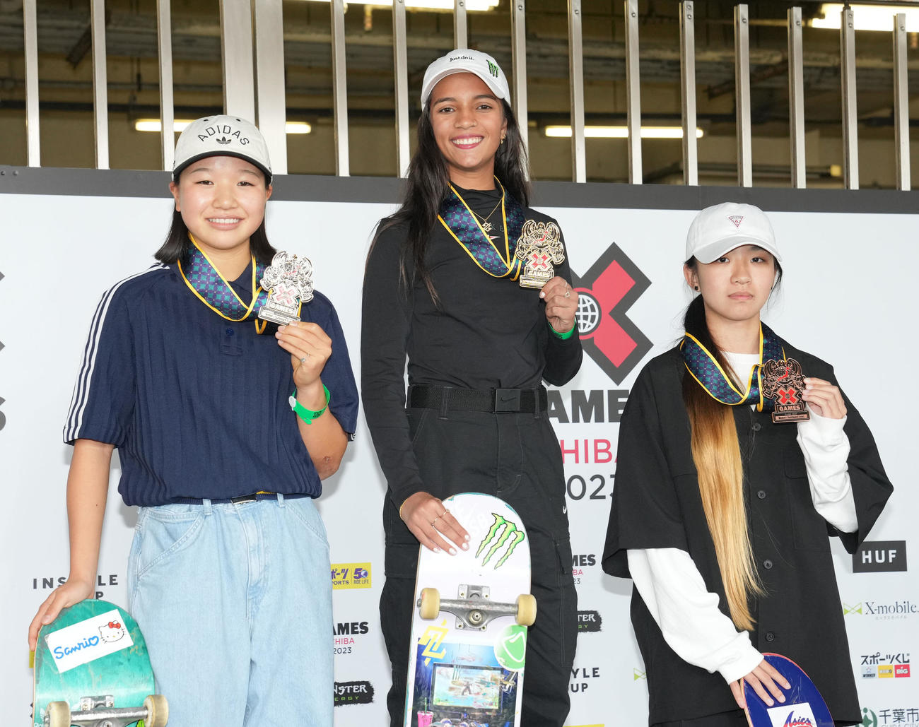 女子スケートボードストリートの表彰式で笑顔を見せる、左から2位の西矢、優勝したレアウ、3位の赤間（撮影・狩俣裕三）