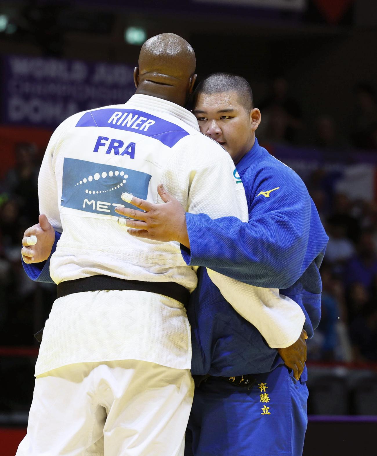 準々決勝でフランスのテディ・リネール（左）に敗れ、健闘をたたえ合う斉藤立（共同）