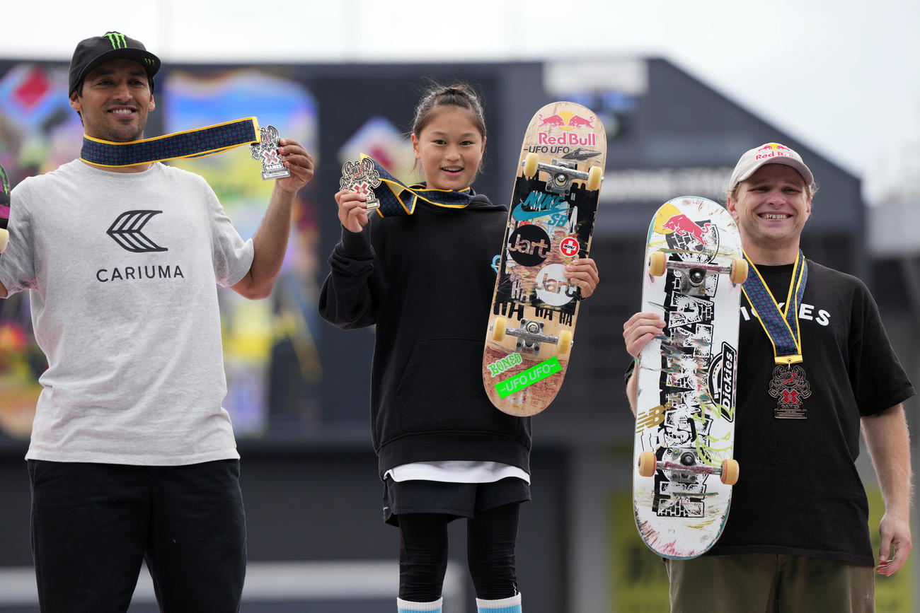 男子スケートボードストリートで優勝し、表彰式で笑顔を見せる小野寺（中央）。左は2位のホフラー、右は3位のフォイ（撮影・狩俣裕三）