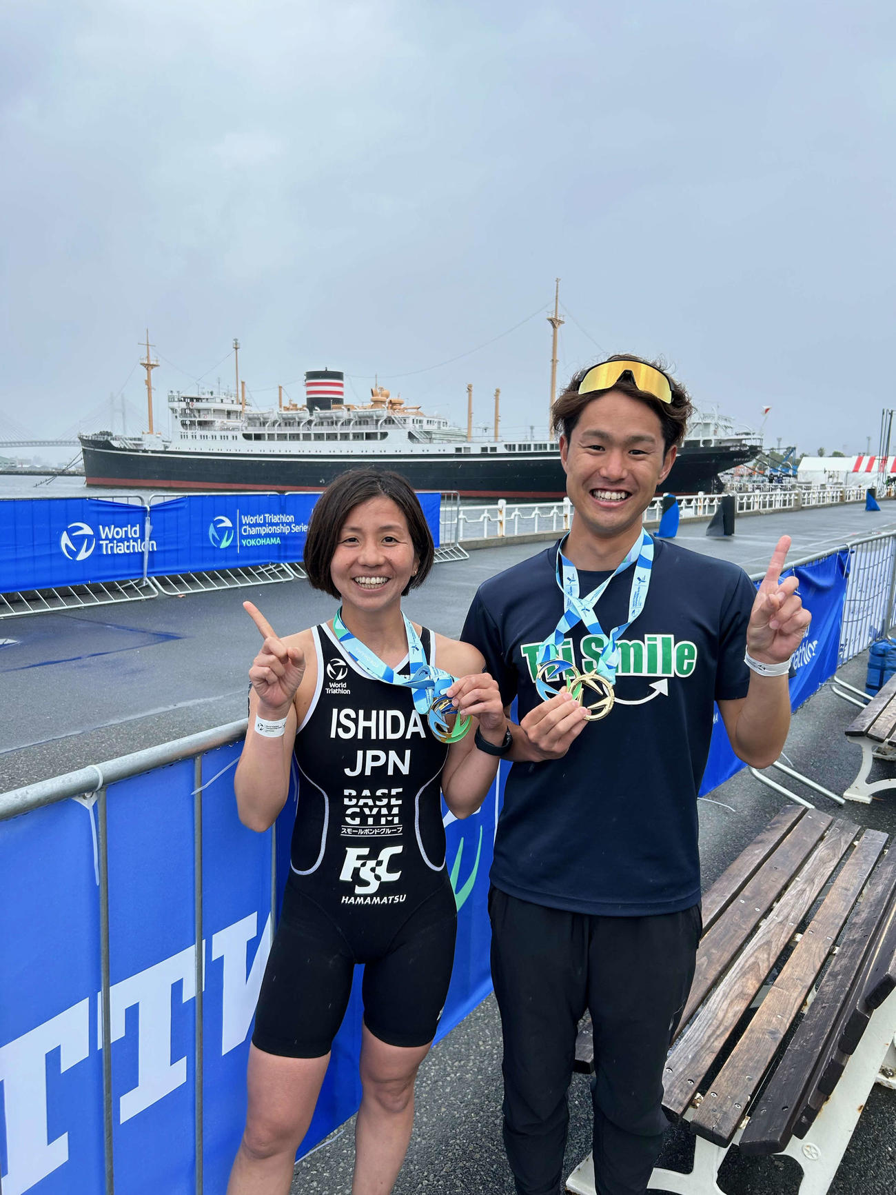 氷川丸をバックに1番ポーズを決め喜ぶ石田凪帆（左）と松浦達也
