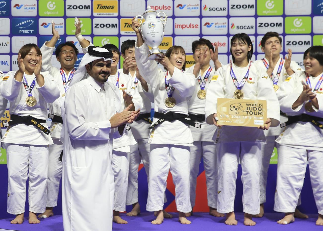 男女混合団体戦　優勝を祝福されながら、トロフィーを持って喜ぶ日本の選手たち（AP）