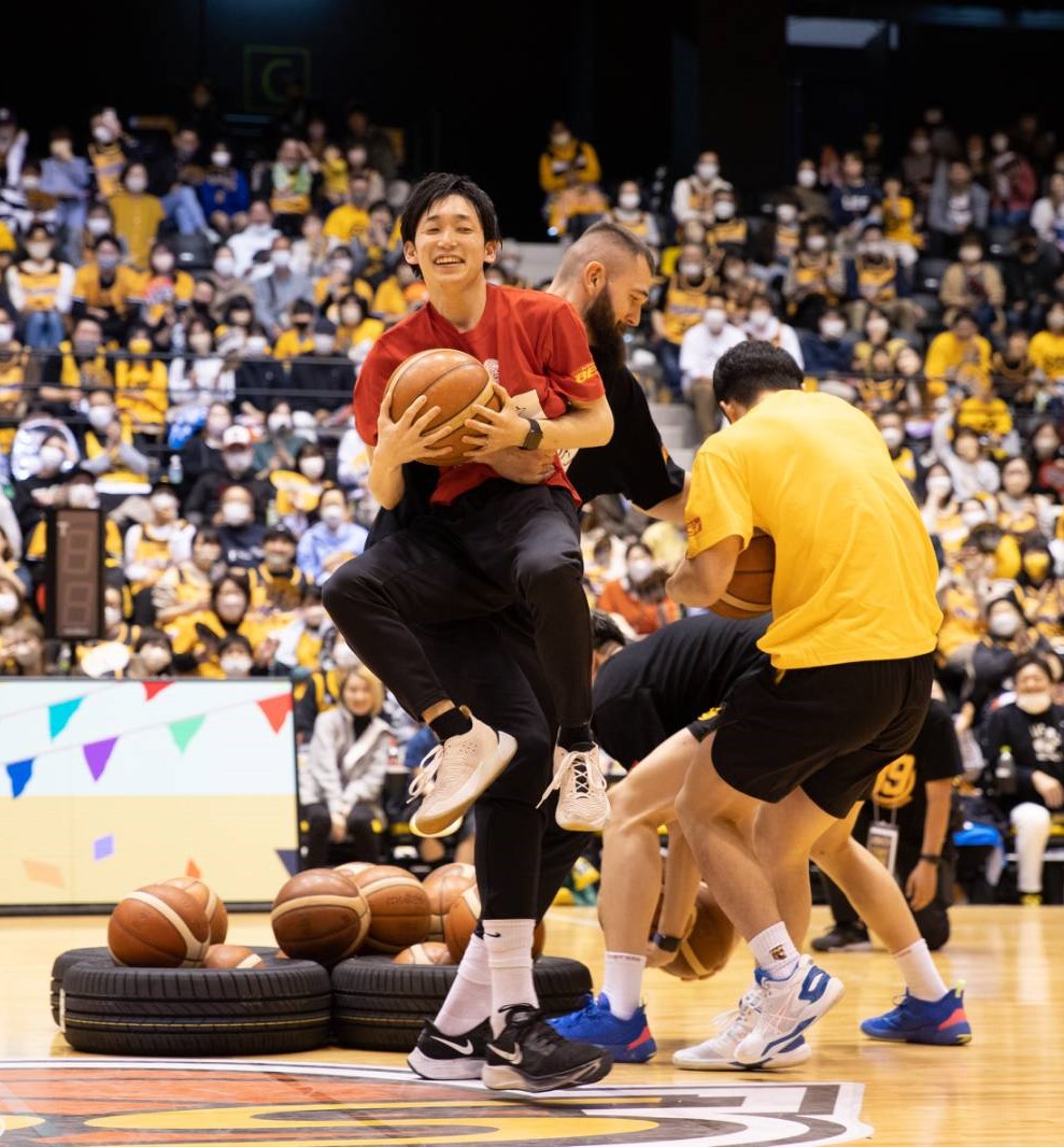 7日、ファン感謝祭大運動会のボール取りゲームで、ブースに抱えられる守屋マネジャー（C）SENDAI 89ERS