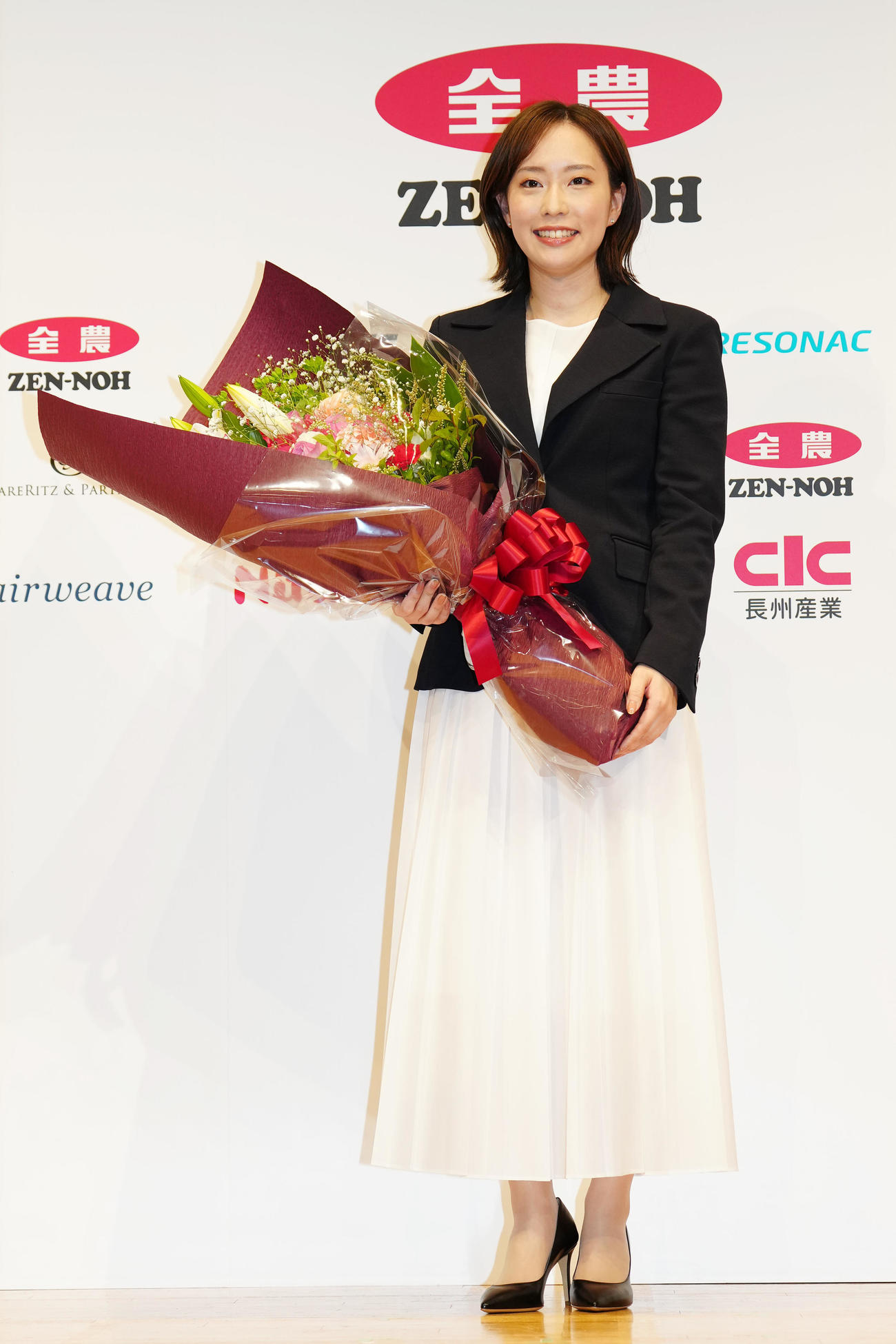 引退会見後、花束を手に写真に納まる石川さん（撮影・江口和貴）