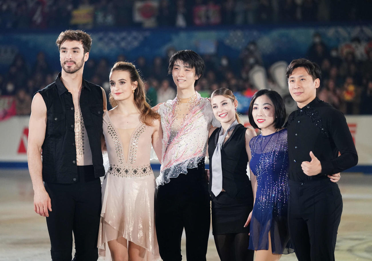 NHK杯　エキシビションの演技を終え、記念写真を撮影する各部門金メダリストの、左からアイスダンスのギオーム・シゼロン、ガブリエラ・パパダキス組、男子シングルの羽生結弦、女子シングルのアリョーナ・コストルナヤ、ペアのウェンジン・スイとツォン・ハン組（2019年11月撮影）