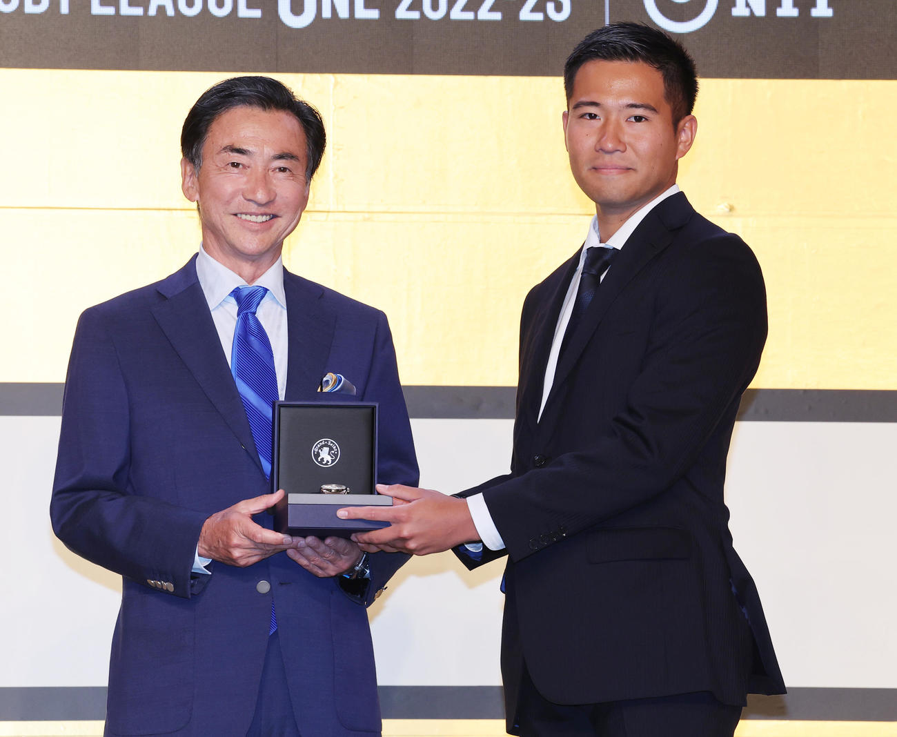リーグワン2022－2023アワードでベストホイッスル賞を受賞しセイコーグループ服部会長兼CEO（左）から副賞の時計を受け取る早大・古瀬レフリー（撮影・野上伸悟）