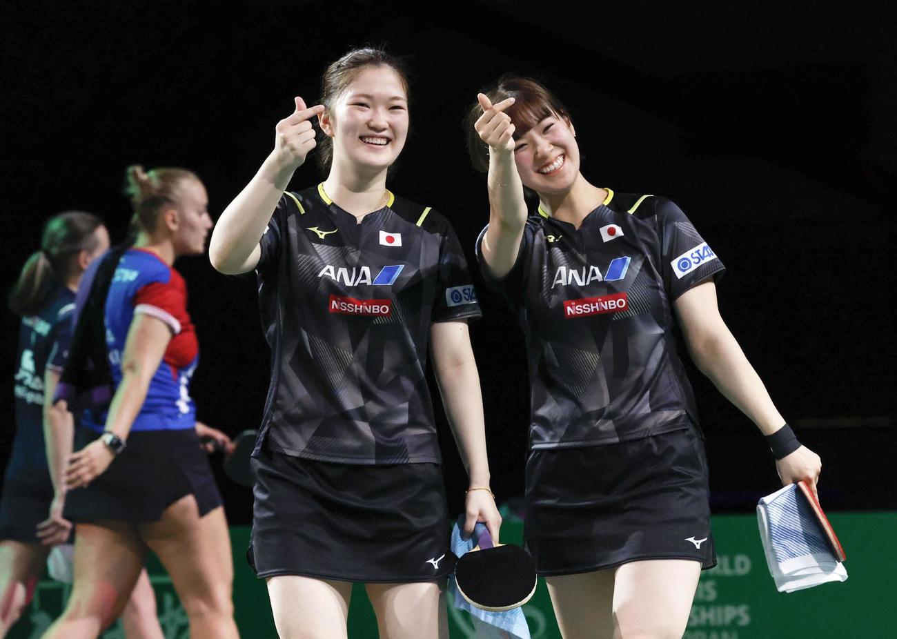 女子ダブルス準々決勝で勝利し、笑顔の木原美悠（手前左）、長崎美柚組。銅メダル以上が確定した（共同）