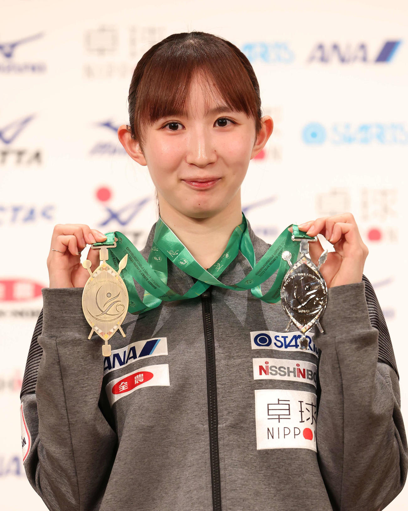 個人戦の銅メダル（左）と混合ダブルスの銀メダルを手に写真に納まる早田（撮影・丹羽敏通）