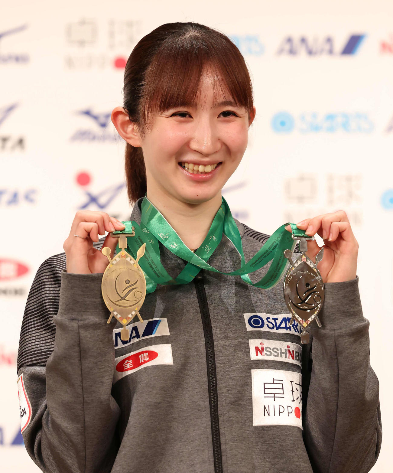 個人戦の銅メダル（左）と混合ダブルスの銀メダルを手に写真に納まる早田（撮影・丹羽敏通）