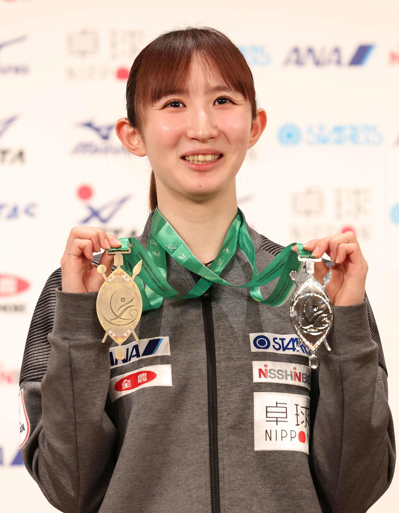 個人戦の銅メダル（左）と混合ダブルスの銀メダルを手に写真に納まる早田（撮影・丹羽敏通）