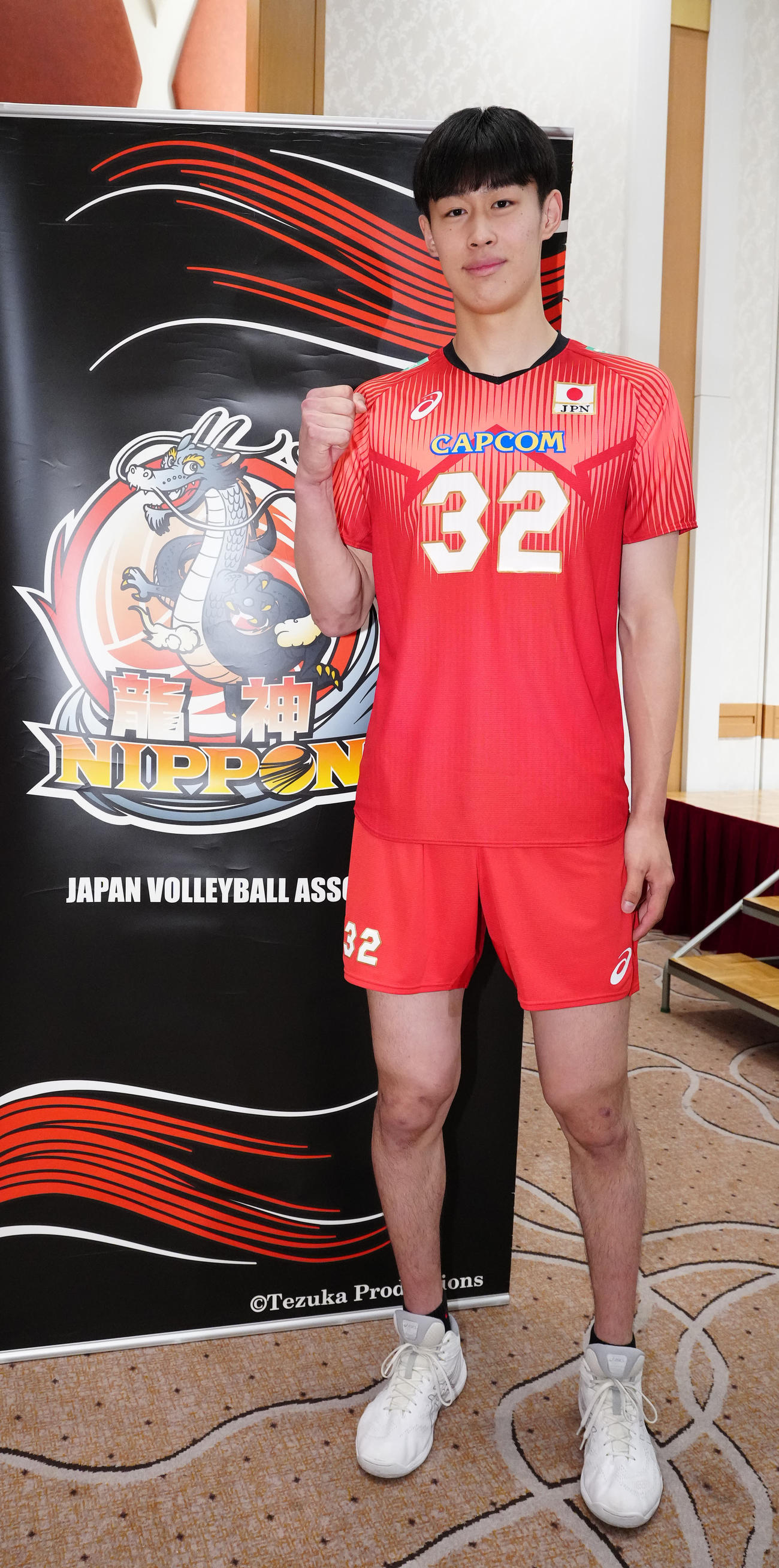 龍神NIPPONのロゴの横で写真に納まるバレーボール男子日本代表の麻野（撮影・江口和貴）