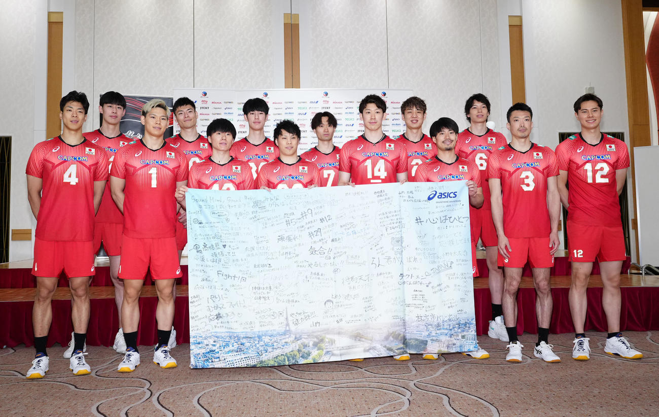 ファンからのメッセージが入った旗と写真に納まるバレーボール男子日本代表の選手たち（撮影・江口和貴）