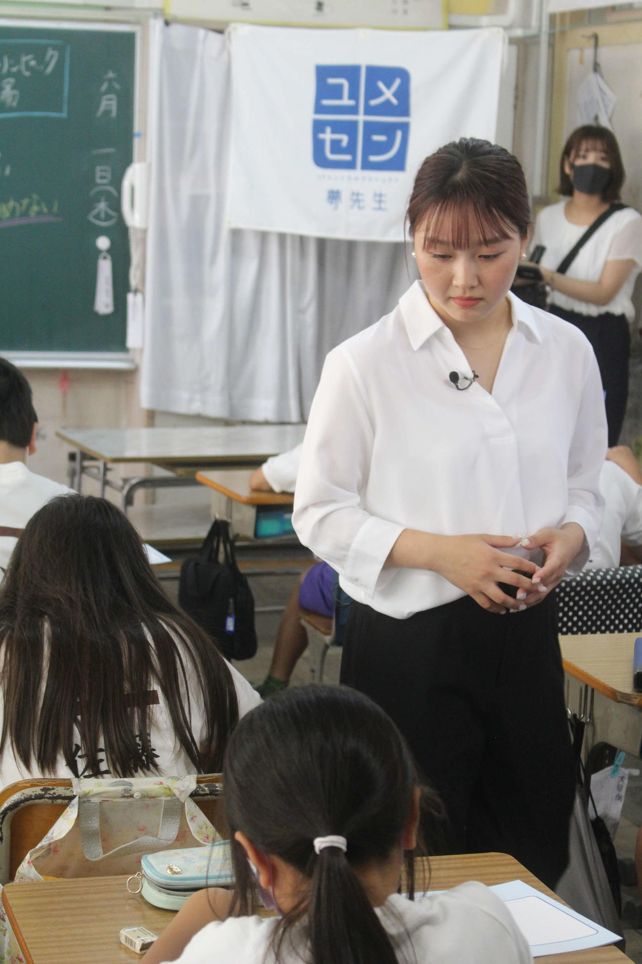 生徒が夢について書く姿を見守る樋口