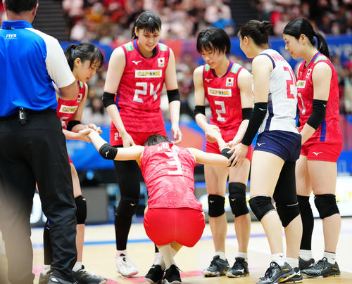 日本対中国　第2セット、ボールが顔に当たり、チームメートに心配される古賀（下）（撮影・江口和貴）