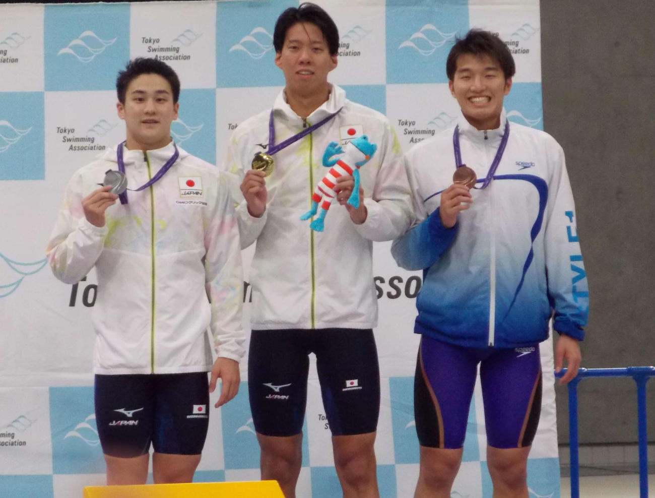 東京都選手権の男子200メートル平泳ぎを制した渡辺一平（中央）と2位の佐藤翔馬（左）、3位の深沢大和（撮影・松本航）
