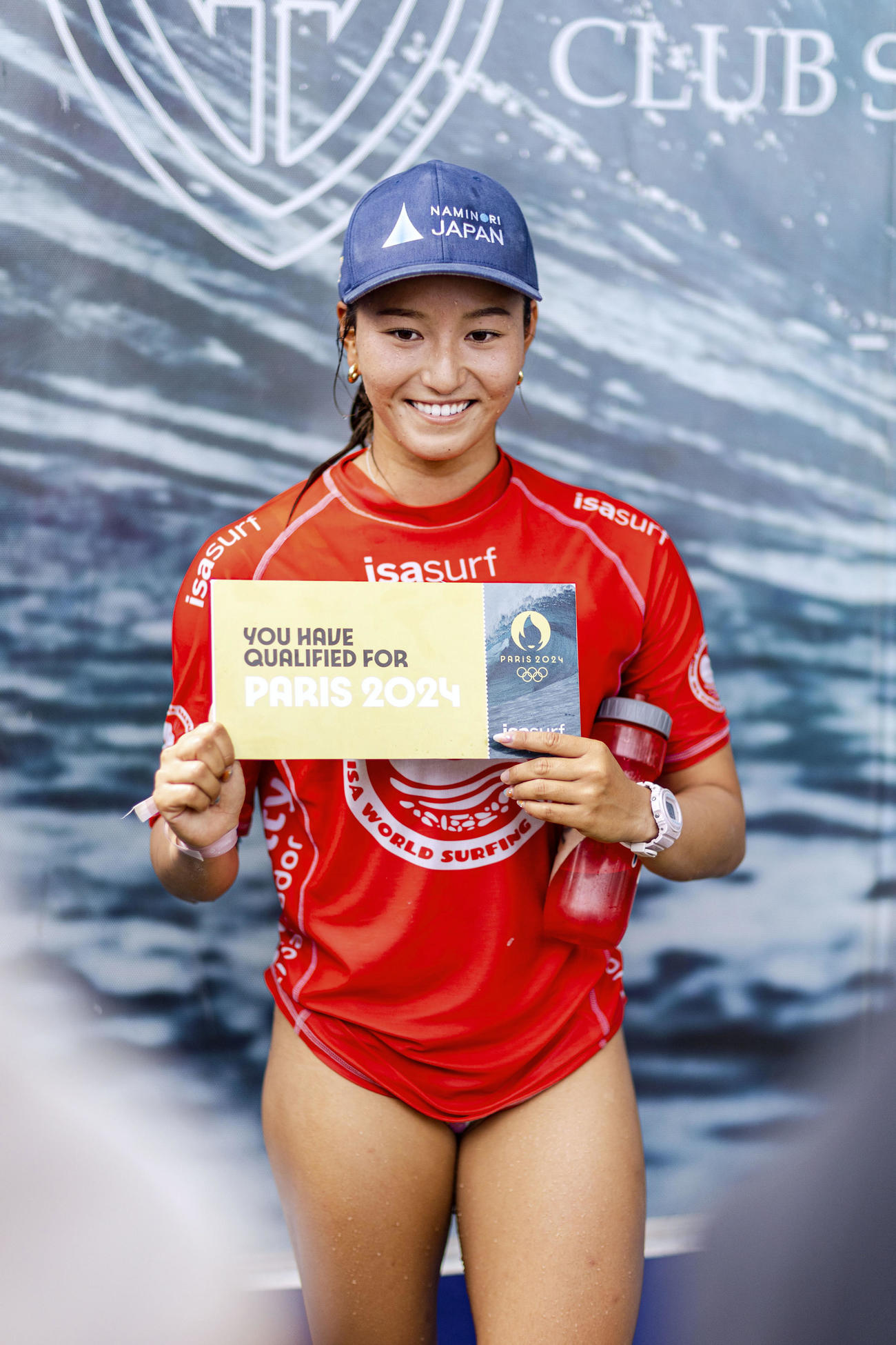 サーフィンのワールドゲームズ女子でアジア最上位が確定し「五輪出場権」と書かれたボードを持つ松田詩野（ISA／Jersson　Barboza提供＝共同）