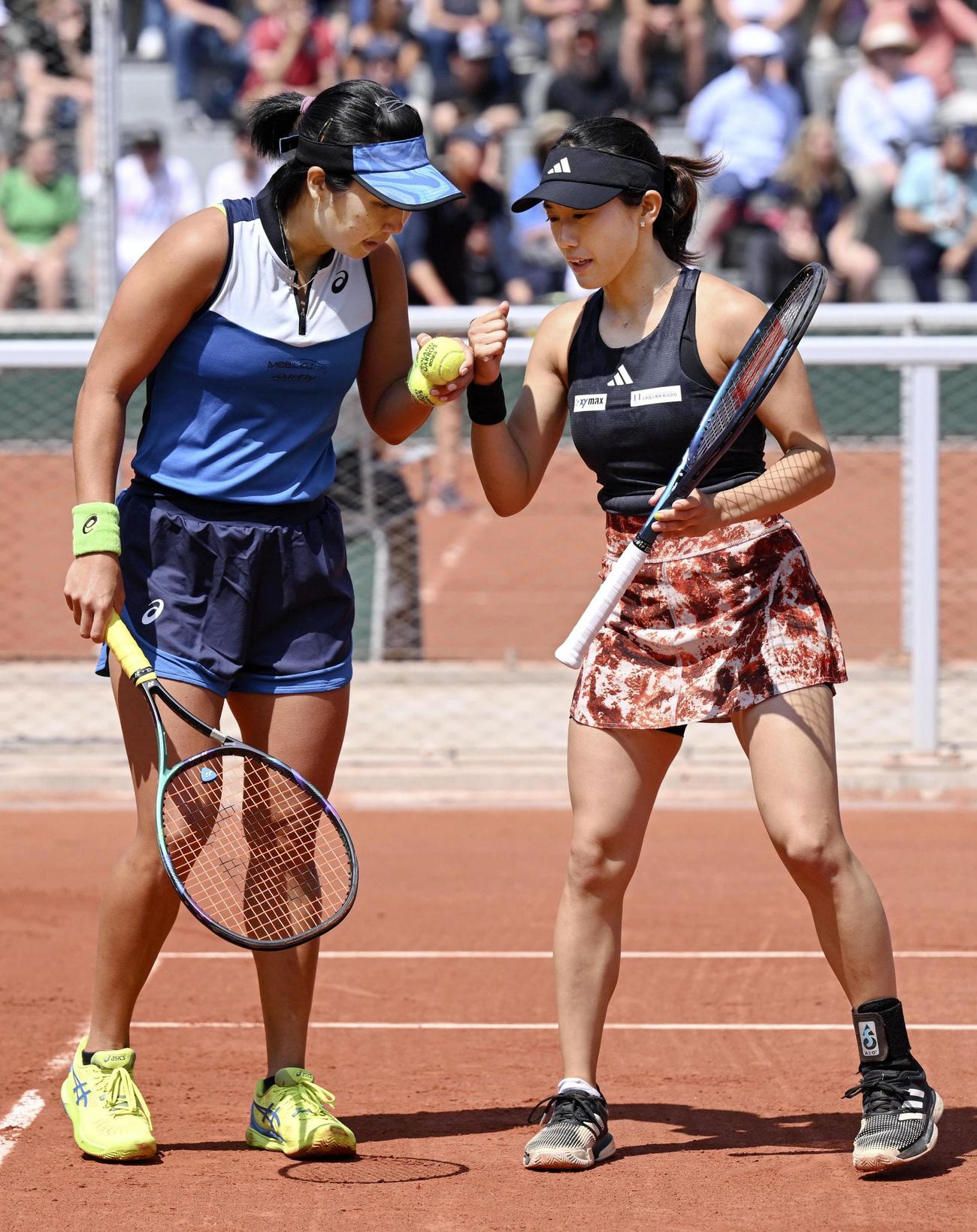 女子ダブルス2回戦でポイントを奪い、タッチを交わす加藤未唯（右）、アルディラ・スーチャディ組（共同）