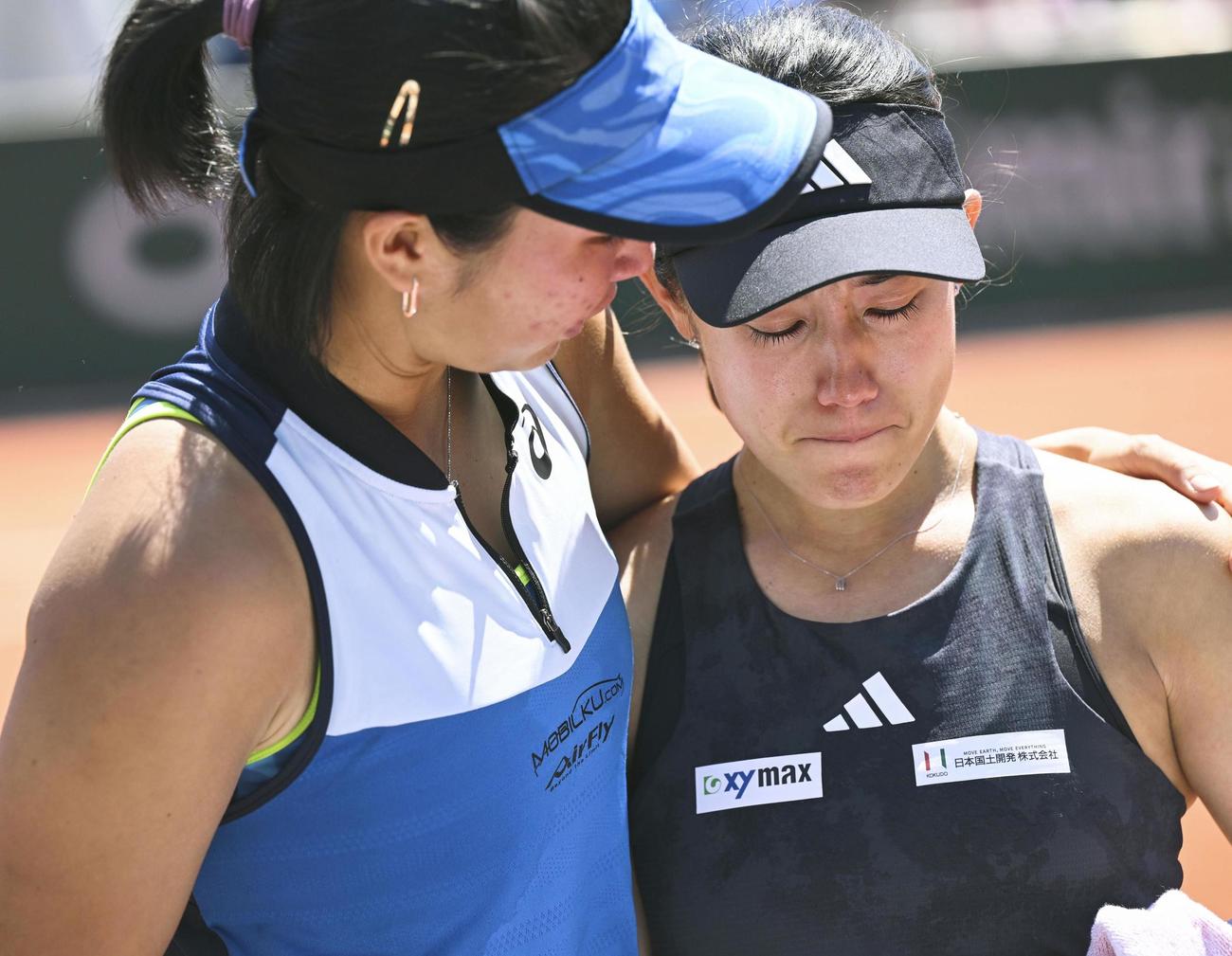 4日、女子ダブルス3回戦で失格となり、涙ぐむ加藤未唯（右）とアルディラ・スーチャディ（共同）