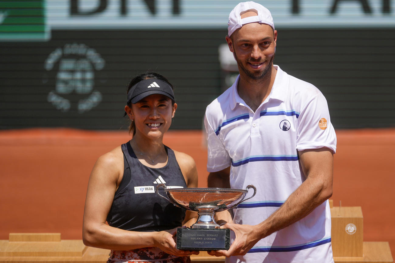 混合ダブルスで優勝を飾り優勝カップを持つ加藤未唯（左）、ティム・プッツ組（AP）