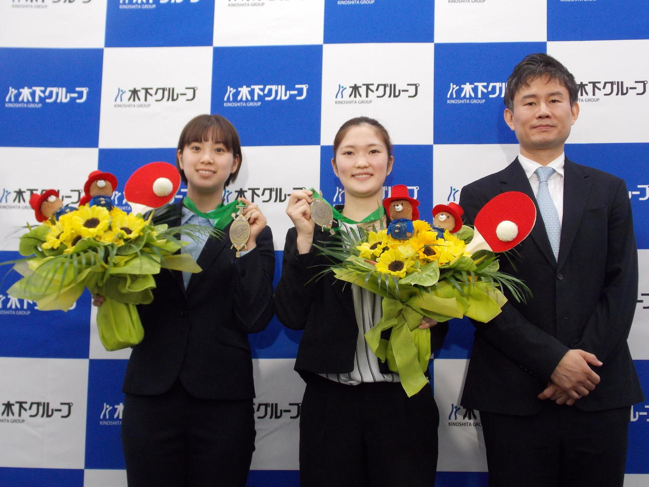 所属する木下グループでパディントンつきの花束を受け取り、笑顔を見せる左から長崎美柚、木原美悠と中沢鋭監督（撮影・松本航）