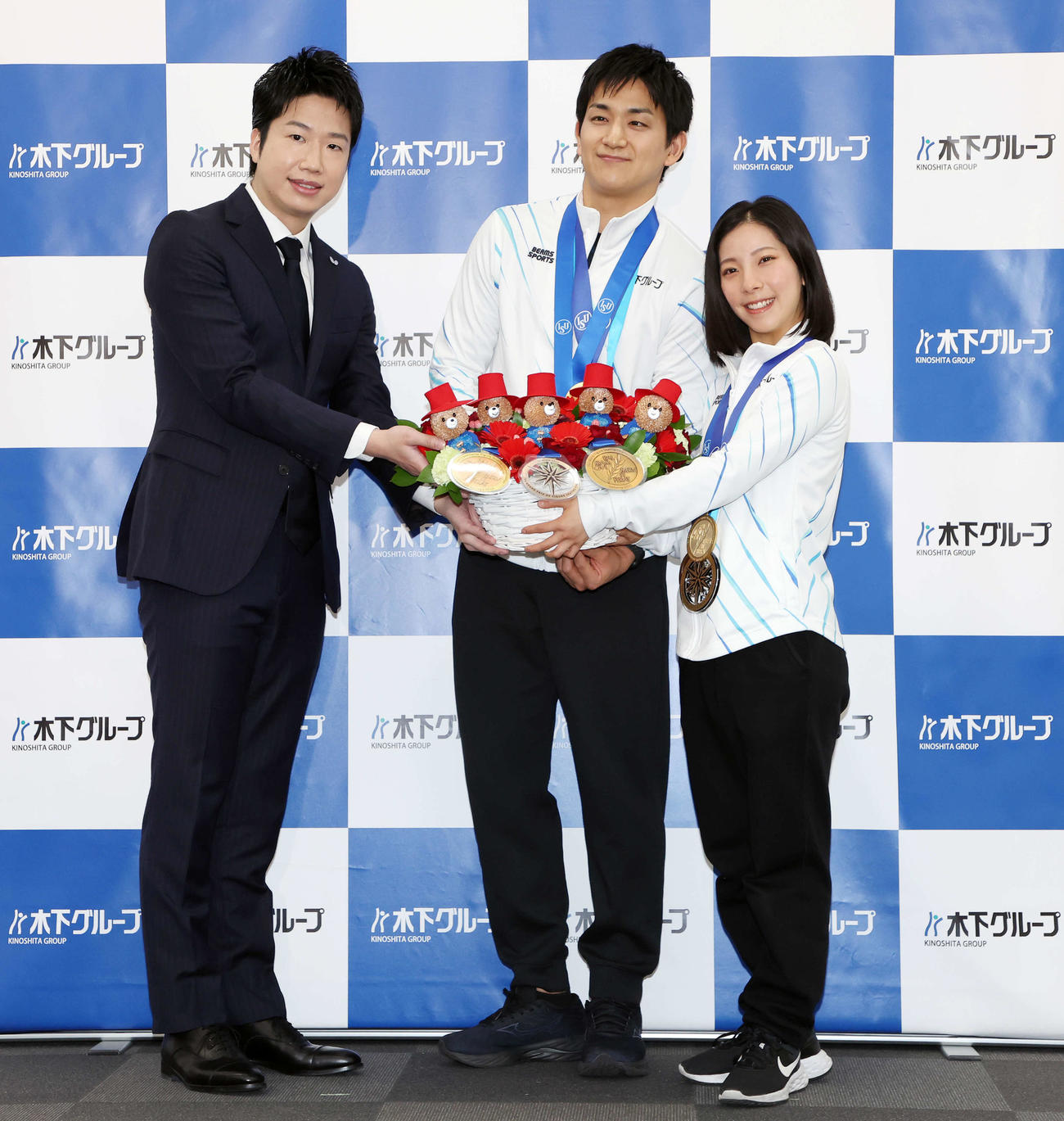 年間グランドスラム達成報告会で水谷隼氏（左）からパディントンつきの花束を受け取る木原（中央）と三浦組（2023年4月25日撮影）