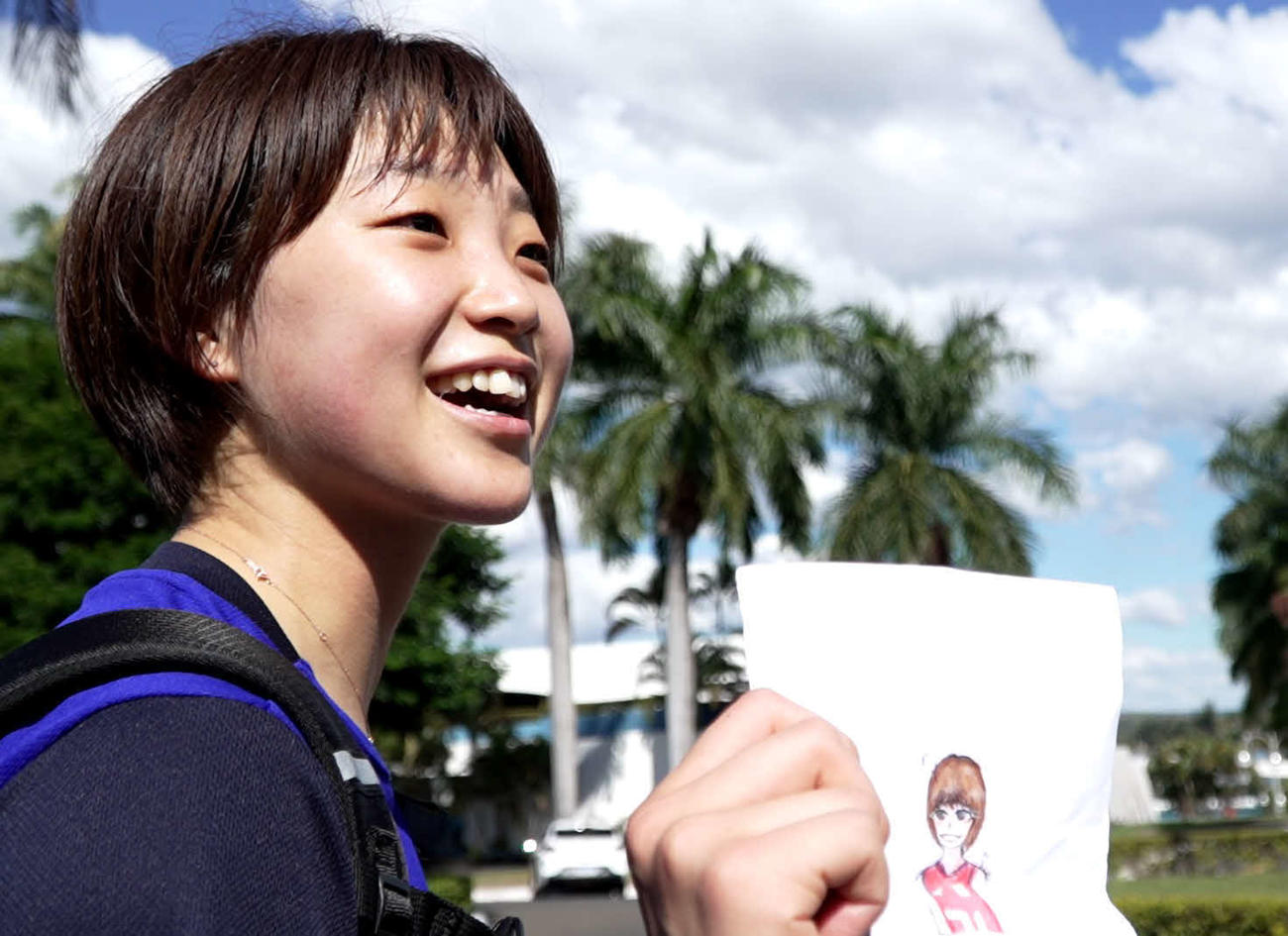 地元の子どものファンからの贈り物を見せながら笑顔の松井