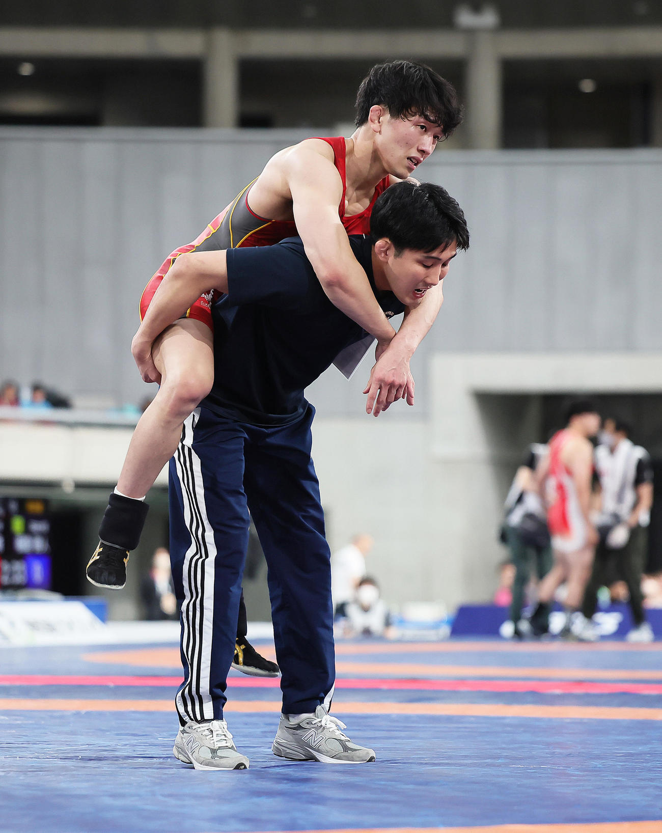 男子65キロ級準決勝　乙黒（上）は山口に勝利するも足を痛め、おんぶされマットを降りる（撮影・足立雅史）