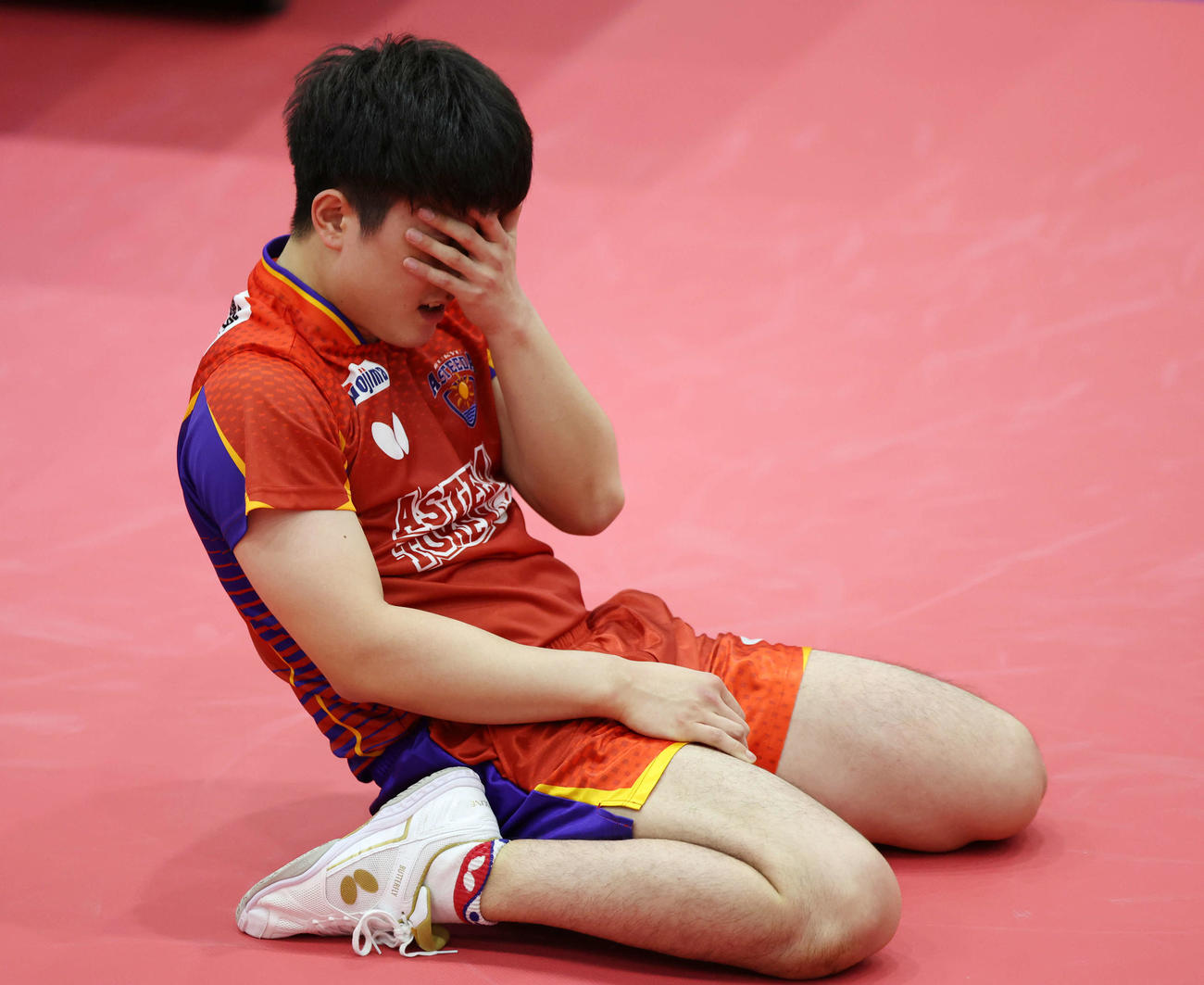 男子シングルス準々決勝　有延大夢に勝利し、顔を押さえ、床に座り込む張本智和（撮影・宮地輝）