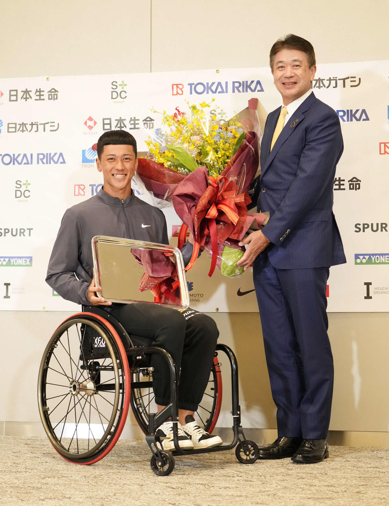 車いす全仏オープンで優勝し帰国会見でプレートを手に所属する株式会社東海理化の二之夕代表取締役社長（右）から花束贈呈を受けるプロテニスプレーヤーの小田（撮影・小沢裕）