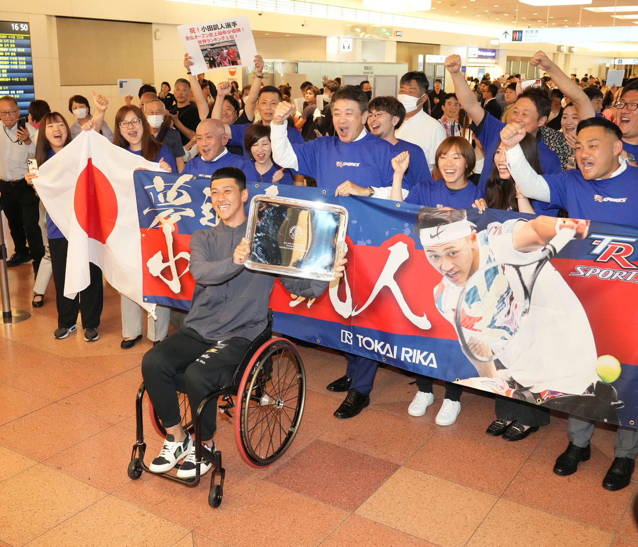 全仏オープンで優勝し帰国した車いすテニスの小田（手前）は関係者の祝福に笑顔を見せる（撮影・小沢裕）