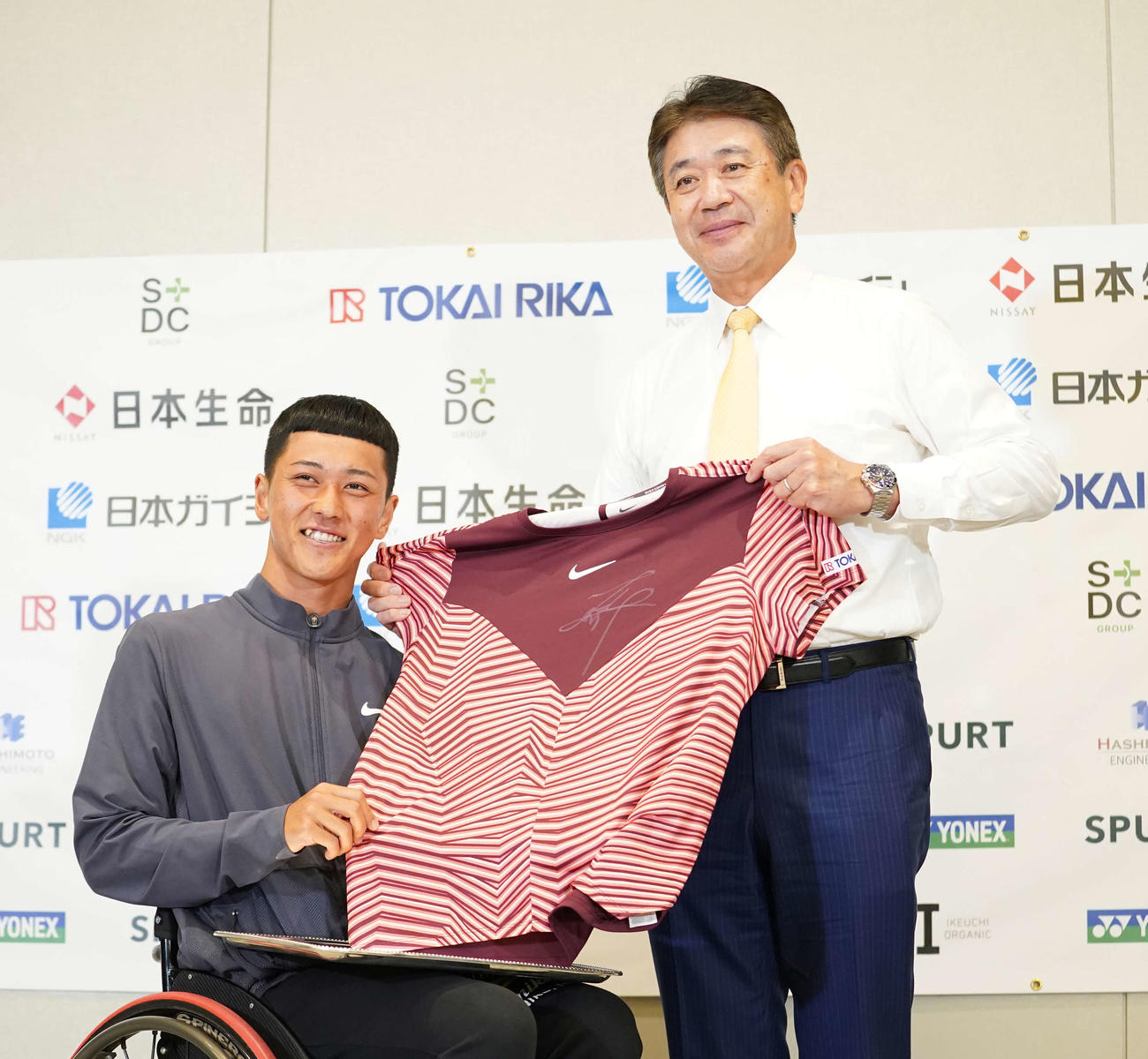 車いす全仏オープンで優勝し帰国会見で所属する株式会社東海理化の二之夕代表取締役社長（右）へ決勝戦で着用したユニホームをプレゼントするプロテニスプレーヤーの小田（撮影・小沢裕）