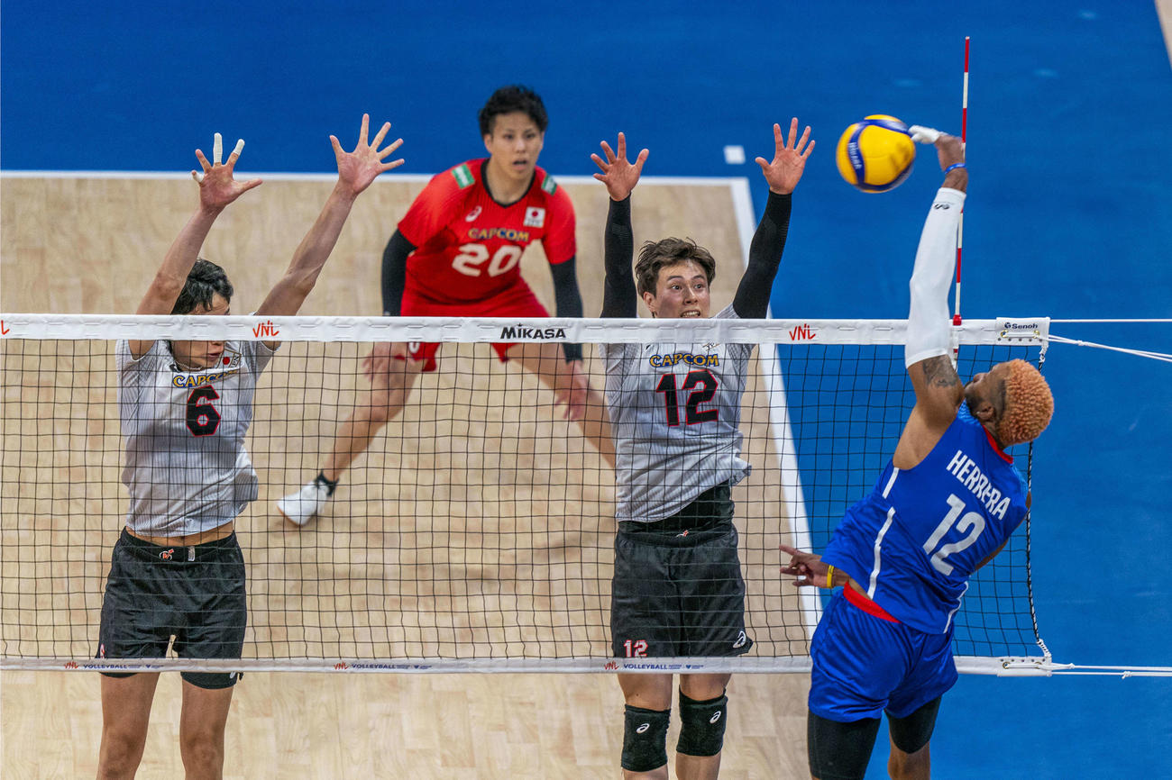 ブロックに跳ぶ高橋藍（右）（C）FIVB