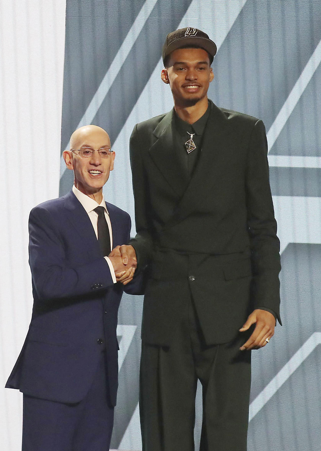 NBAのドラフト会議でスパーズから全体1位指名を受け、シルバー・コミッショナーと握手を交わすビクトル・ウェンバンヤマ（右）（USAトゥデー・ロイター＝共同）