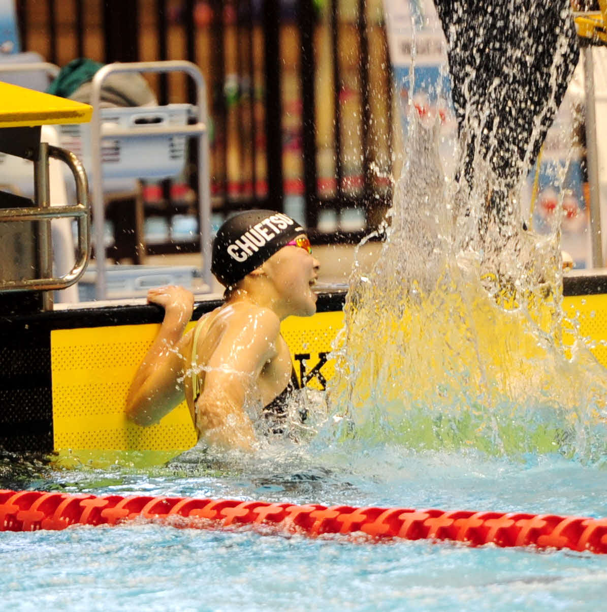 女子100メートル自由形決勝で大会新Vを決め、水しぶきを上げて喜ぶ中越・山田