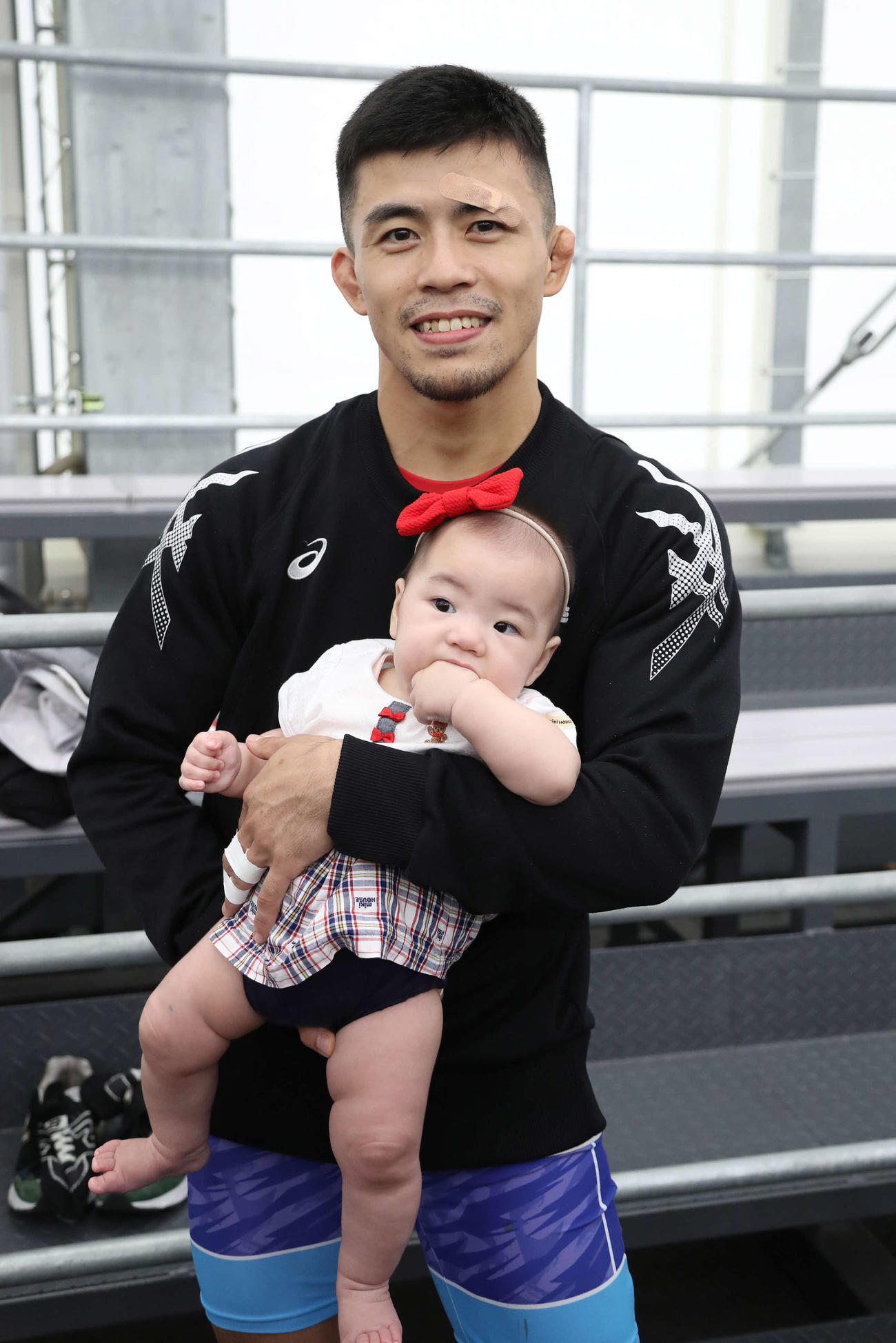 男子グレコローマン60キロ級、試合に勝利して愛娘の遥月ちゃんを抱っこする文田（撮影・丹羽敏通）