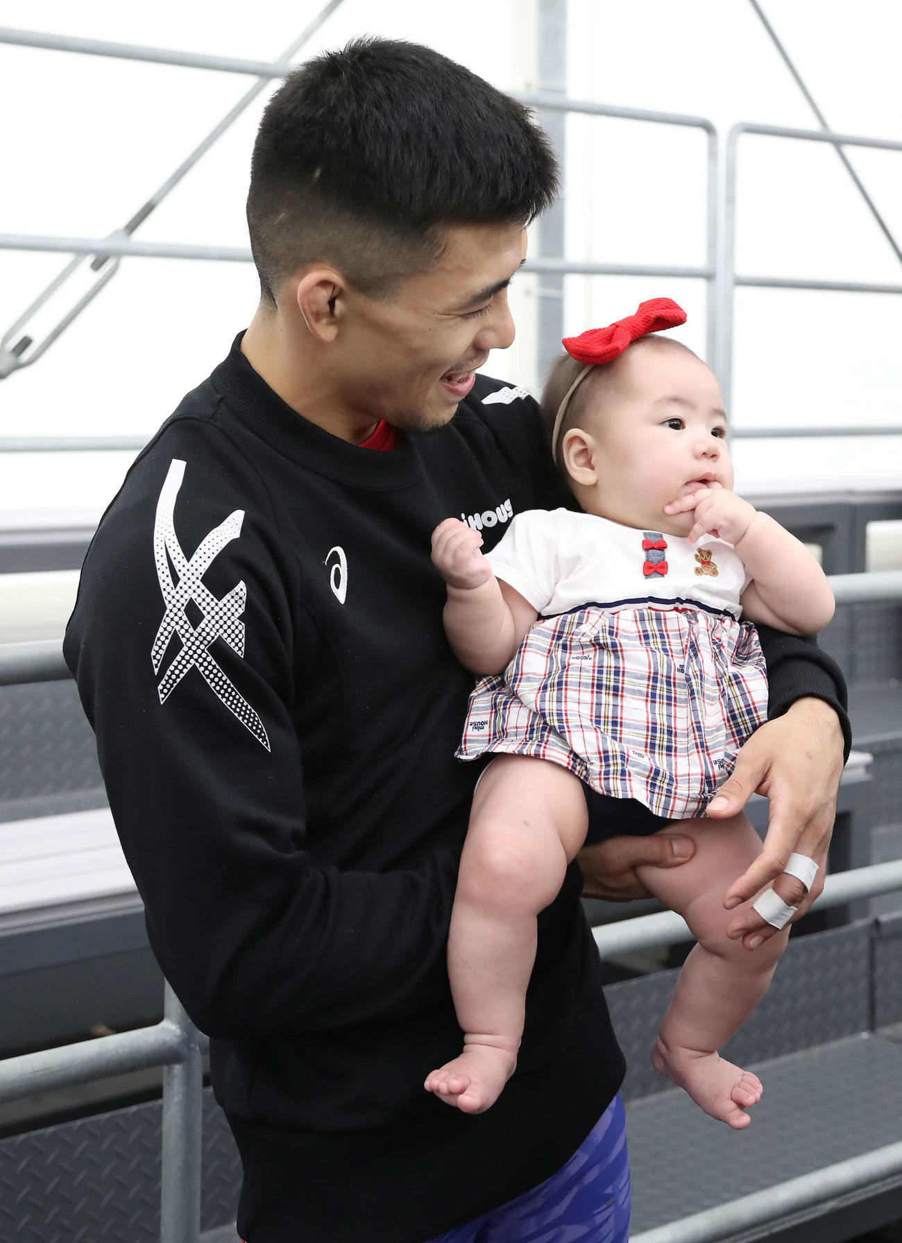男子グレコローマン60キロ級、試合に勝利して愛娘の遥月ちゃんを抱っこする文田（撮影・丹羽敏通）