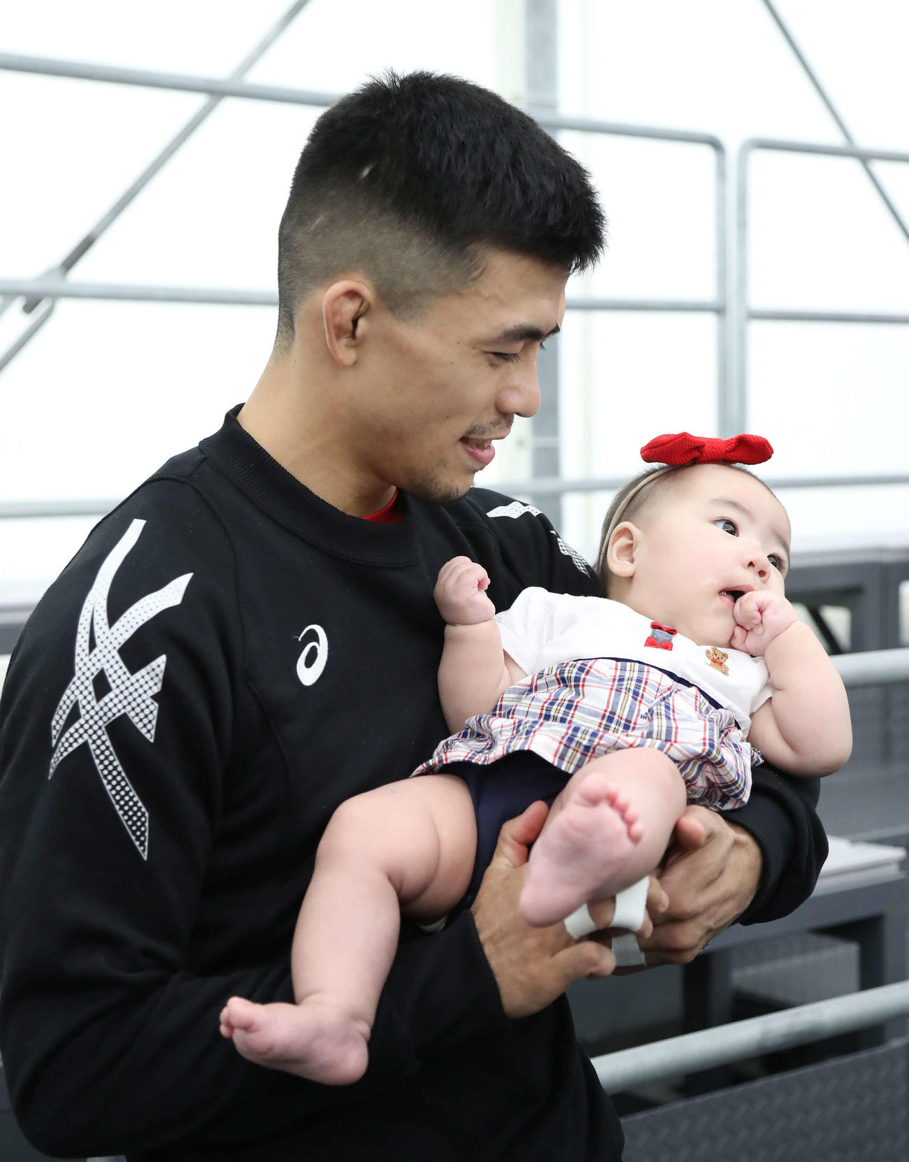 男子グレコローマン60キロ級、試合に勝利して愛娘の遥月ちゃんを抱っこする文田（撮影・丹羽敏通）