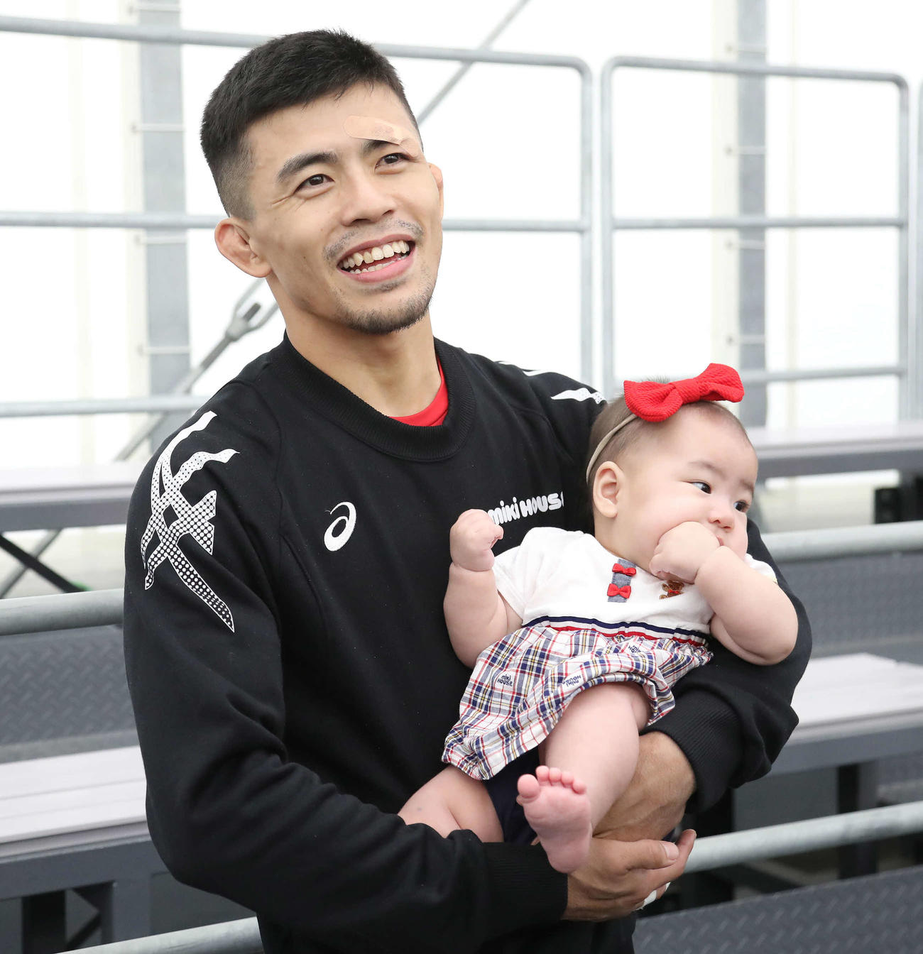 男子グレコローマン60キロ級、試合に勝利して愛娘の遥月ちゃんを抱っこする文田（撮影・丹羽敏通）