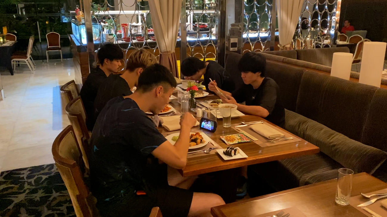 食事をする選手たち。前列奥から関田、西田、高橋健、後列奥から山内、小川（C）JVA