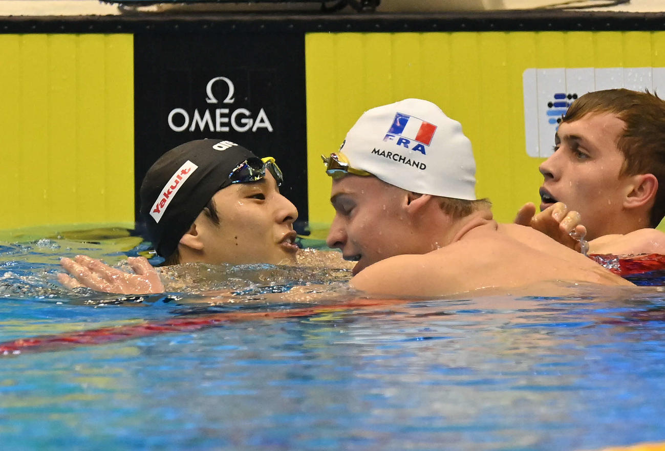 世界水泳2023福岡大会第10日　男子400メートル個人メドレー決勝、世界新記録で優勝したレオン・マルシャン（右から2人目）と抱き合う瀬戸大也（撮影・岩下翔太）
