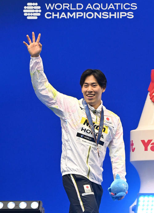 男子200メートルバタフライで3位となり、表彰式を終えて笑顔で移動する本多灯（撮影・岩下翔太）