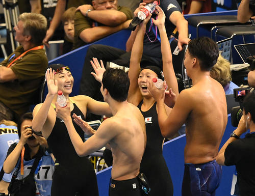 世界水泳2023福岡大会第13日　混合4×100メートルメドレーリレー予選、最終順位で予選突破を確認した池江璃花子（左）ら日本チームは笑顔でタッチを交わす（撮影・岩下翔太）