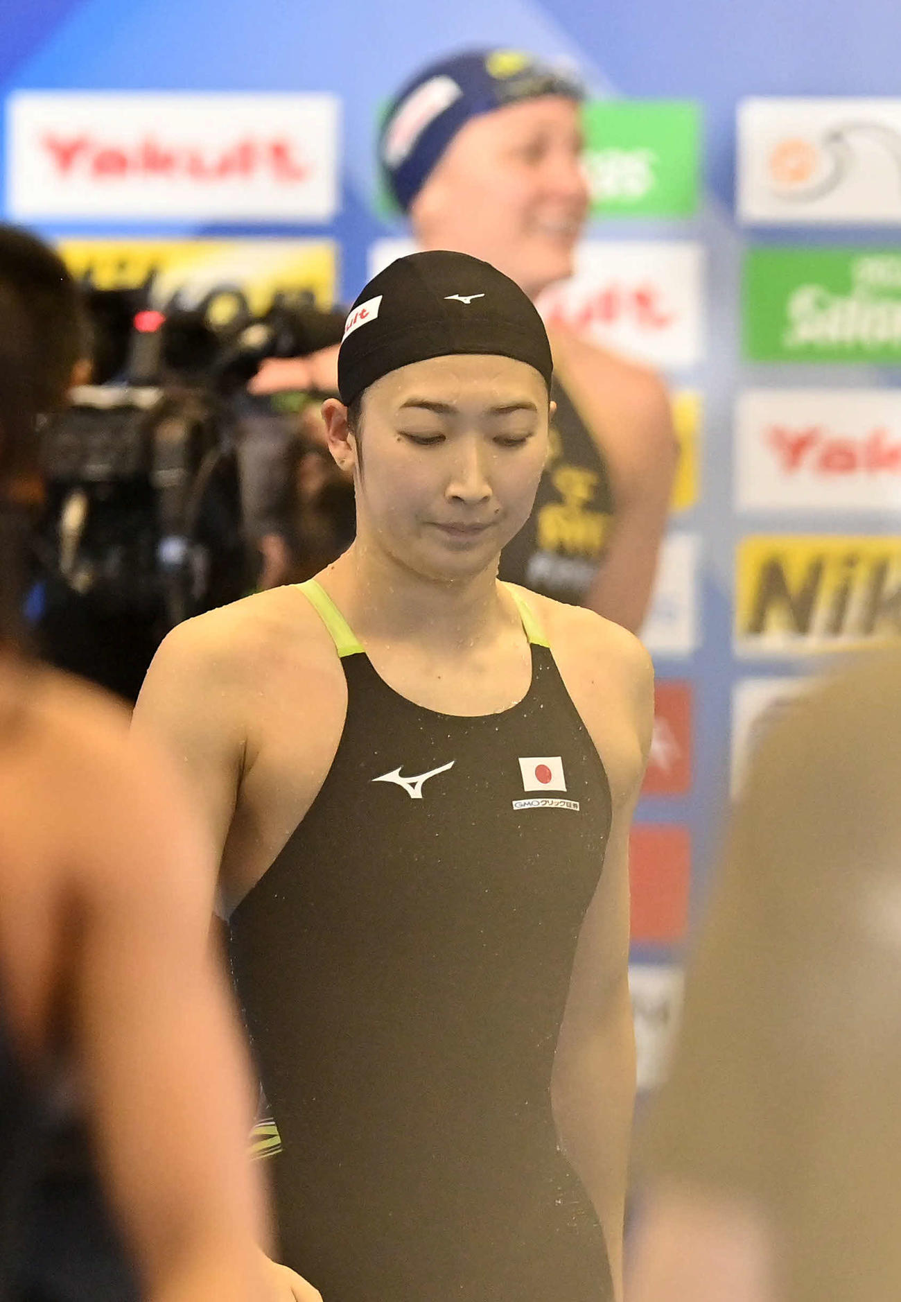 世界水泳2023福岡大会第16日　女子50メートルバタフライ決勝、7着となった池江璃花子は、優勝したサラ・ショーストロムを背に引き揚げる（撮影・岩下翔太）