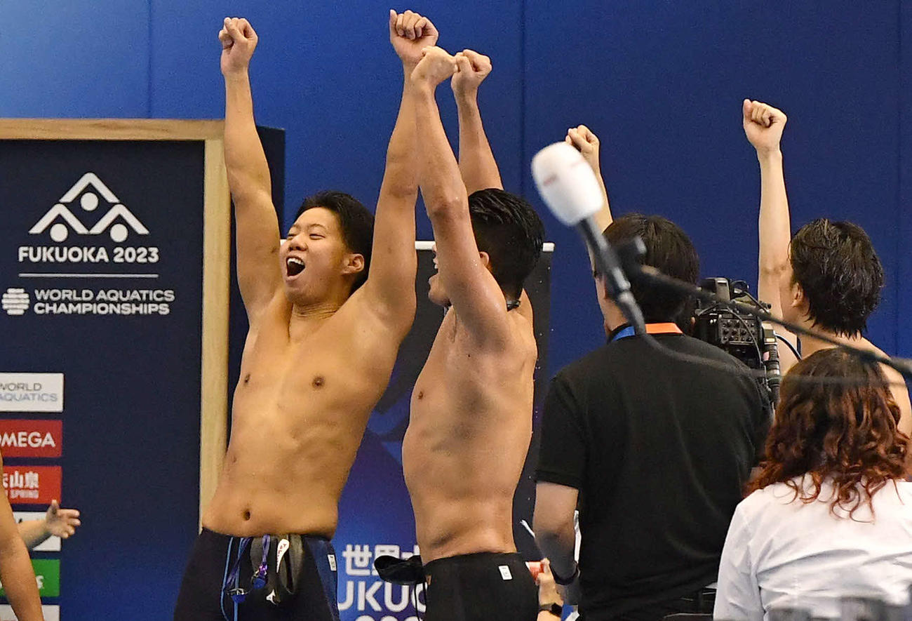 世界水泳2023福岡大会第17日　男子4×100メートルメドレーリレー予選、予選通過を確認し、ガッツポーズして喜ぶ渡辺一平（左）ら日本チーム（撮影・岩下翔太）