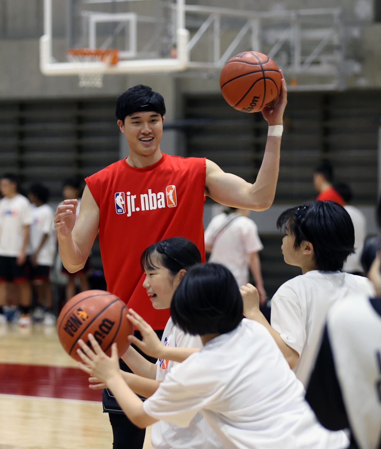 クリニックで子どもたちと笑顔で練習するサンズ渡辺（後方）（撮影・大野祥一）