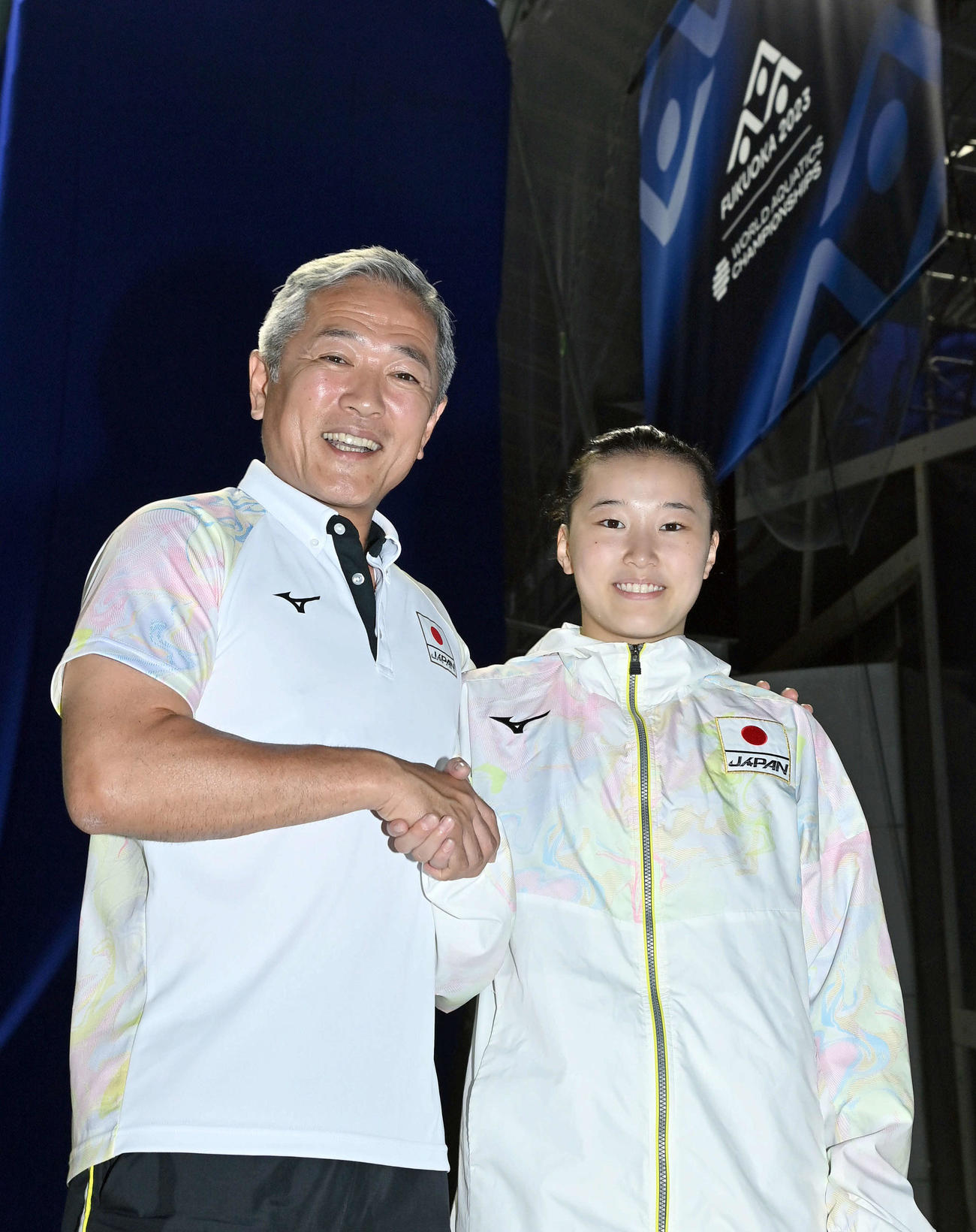 女子3メートル飛板飛び込み準決勝3位で決勝に進出し、パリ五輪代表が事実上内定した三上（右）は安田コーチと握手を交わす（撮影・岩下翔太）