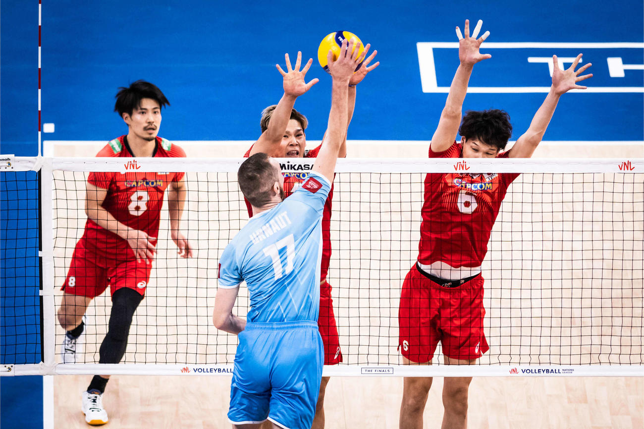 スロベニア戦でブロックに跳ぶ西田（中央）（C）FIVB
