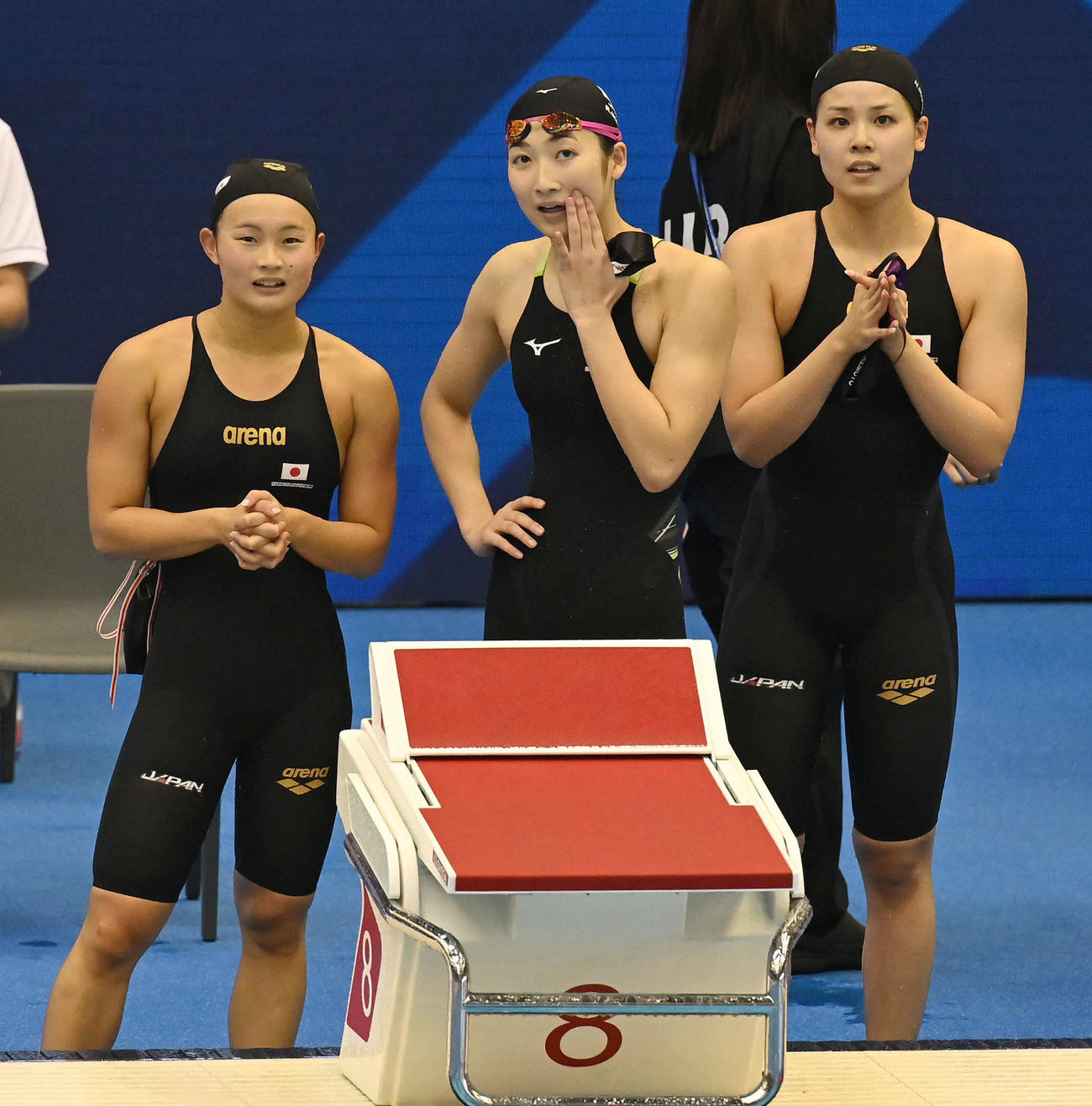 世界水泳2023福岡大会第10日　女子400メートルリレー予選、競技を終えて祈るように電光掲示板を見つめる、左から神野ゆめ、池江璃花子、池本凪沙（撮影・岩下翔太）