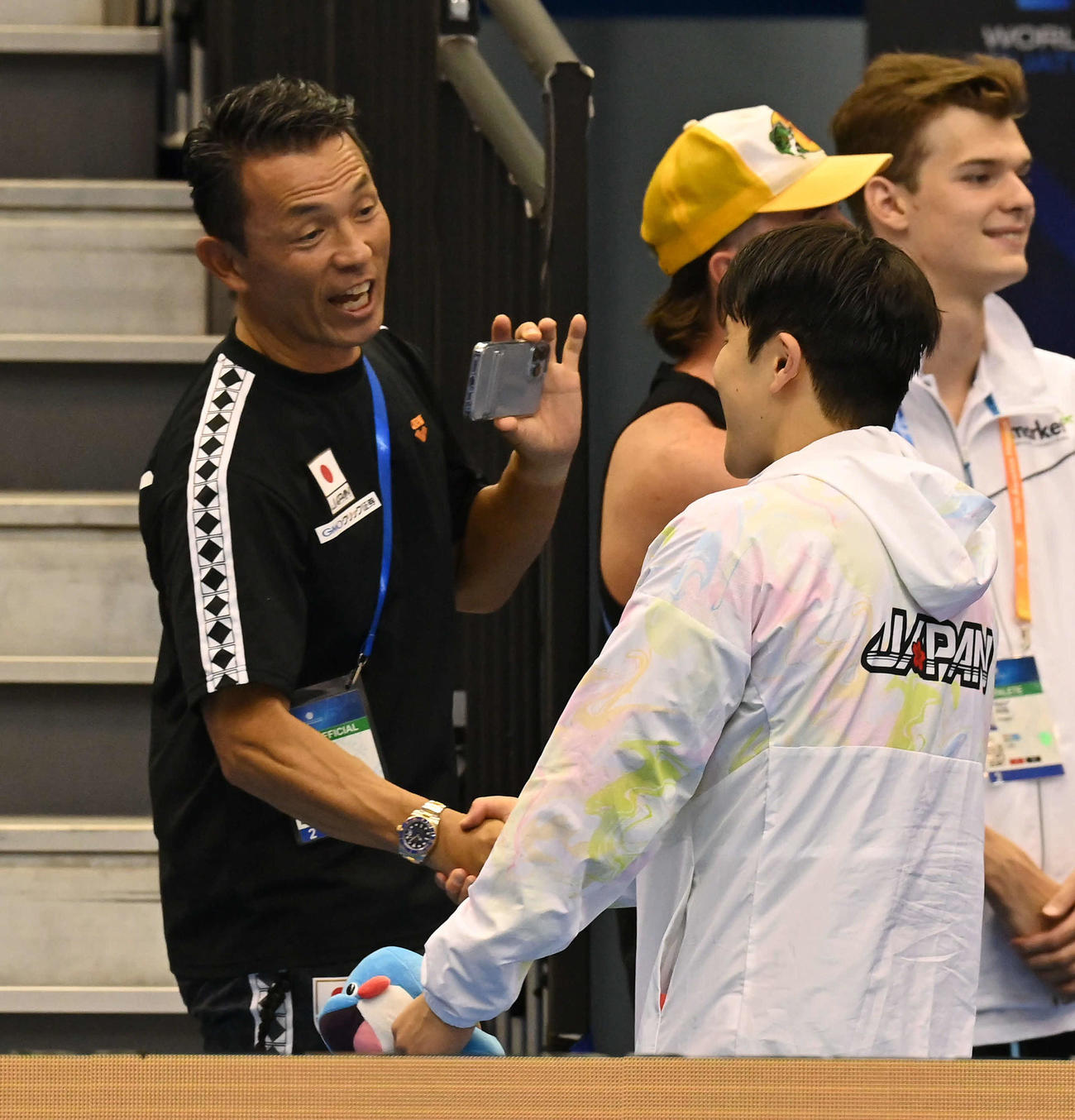 世界水泳2023福岡大会第10日　男子400メートル個人メドレー決勝で銅メダルを獲得した瀬戸大也（右）と握手を交わす加藤健志コーチ（撮影・岩下翔太）