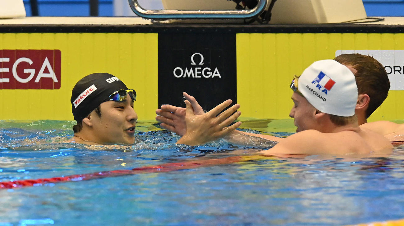 世界水泳2023福岡大会第10日　男子400メートル個人メドレー決勝、世界新記録で優勝したレオン・マルシャン（右から2人目）とタッチを交わす瀬戸大也（撮影・岩下翔太）