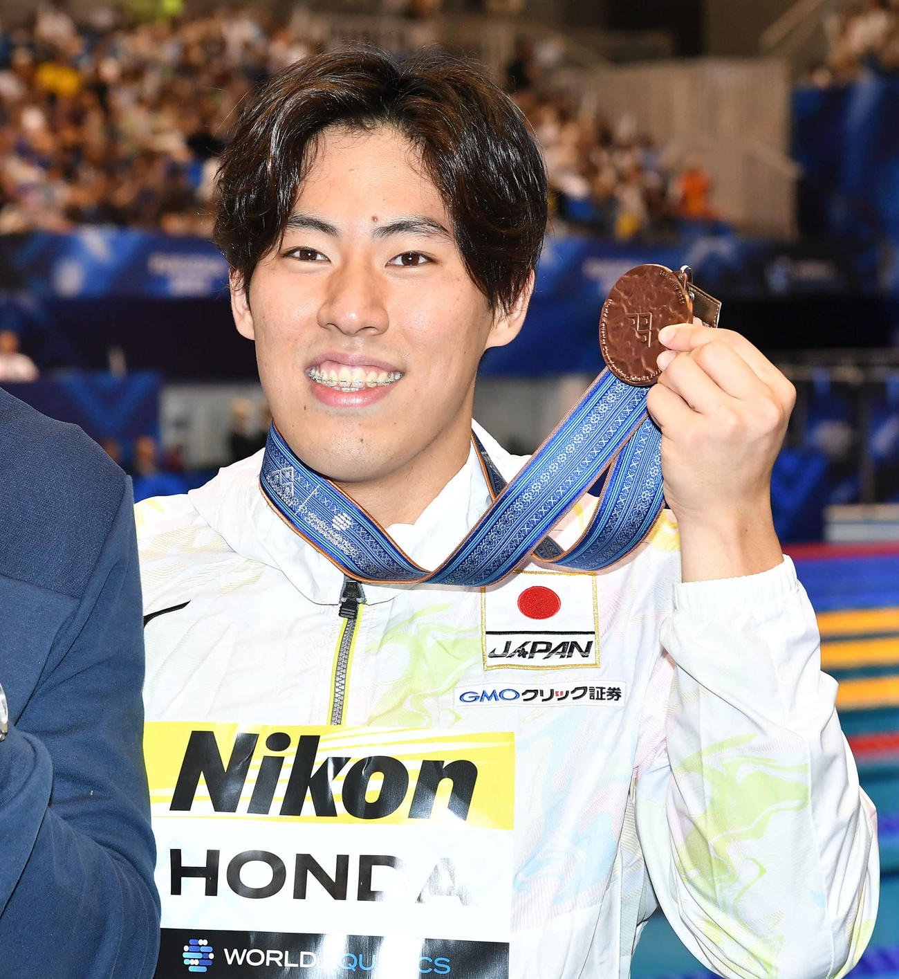 男子200メートルバタフライで3位となり銅メダルを掲げる本多（撮影・岩下翔太）